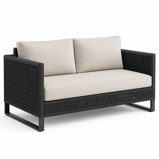 Czarna dwuosobowa sofa z technorattanu z kremowymi poduszkami